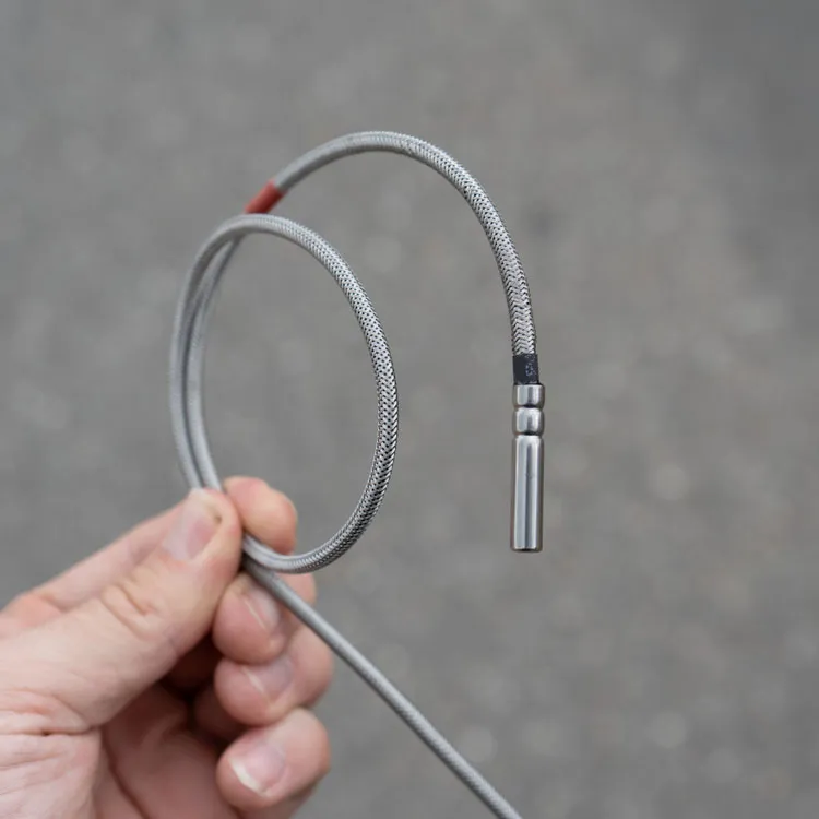 Cordulus Site soil temperature sensor a flexible metal braided cable with a cylindrical metal sensor or probe at the end.