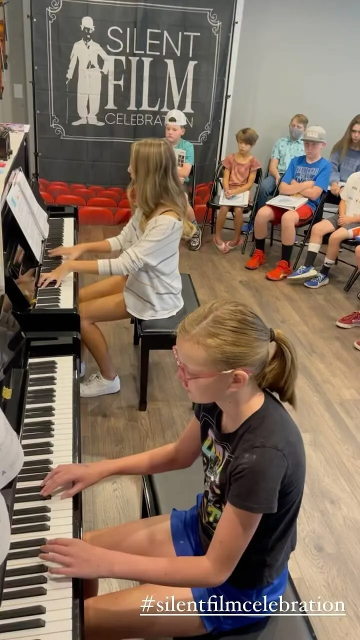 young girls playing pianos