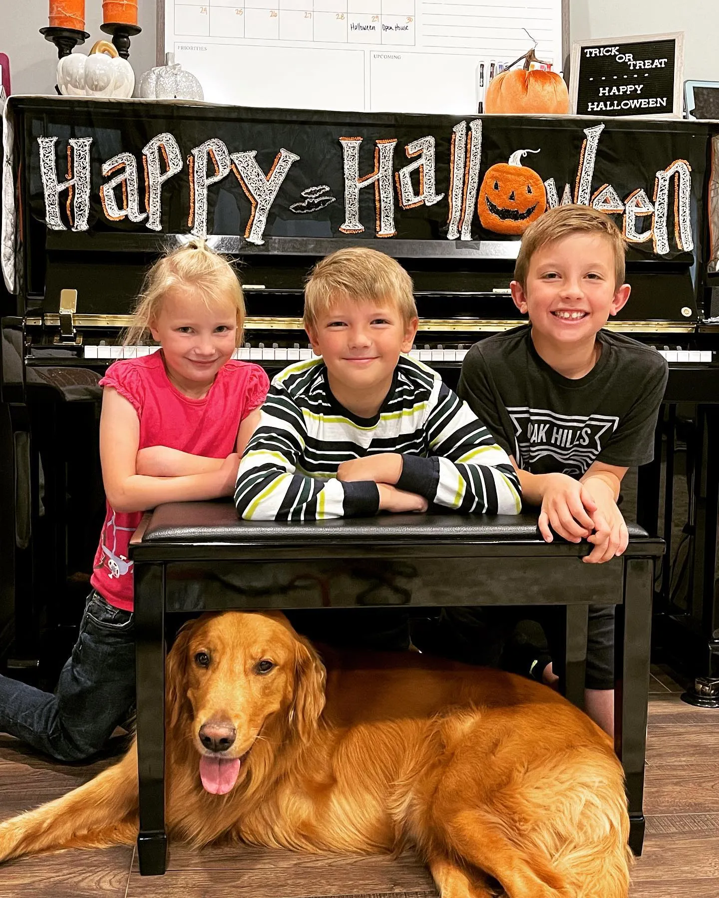 three kids and ollie at piano bench