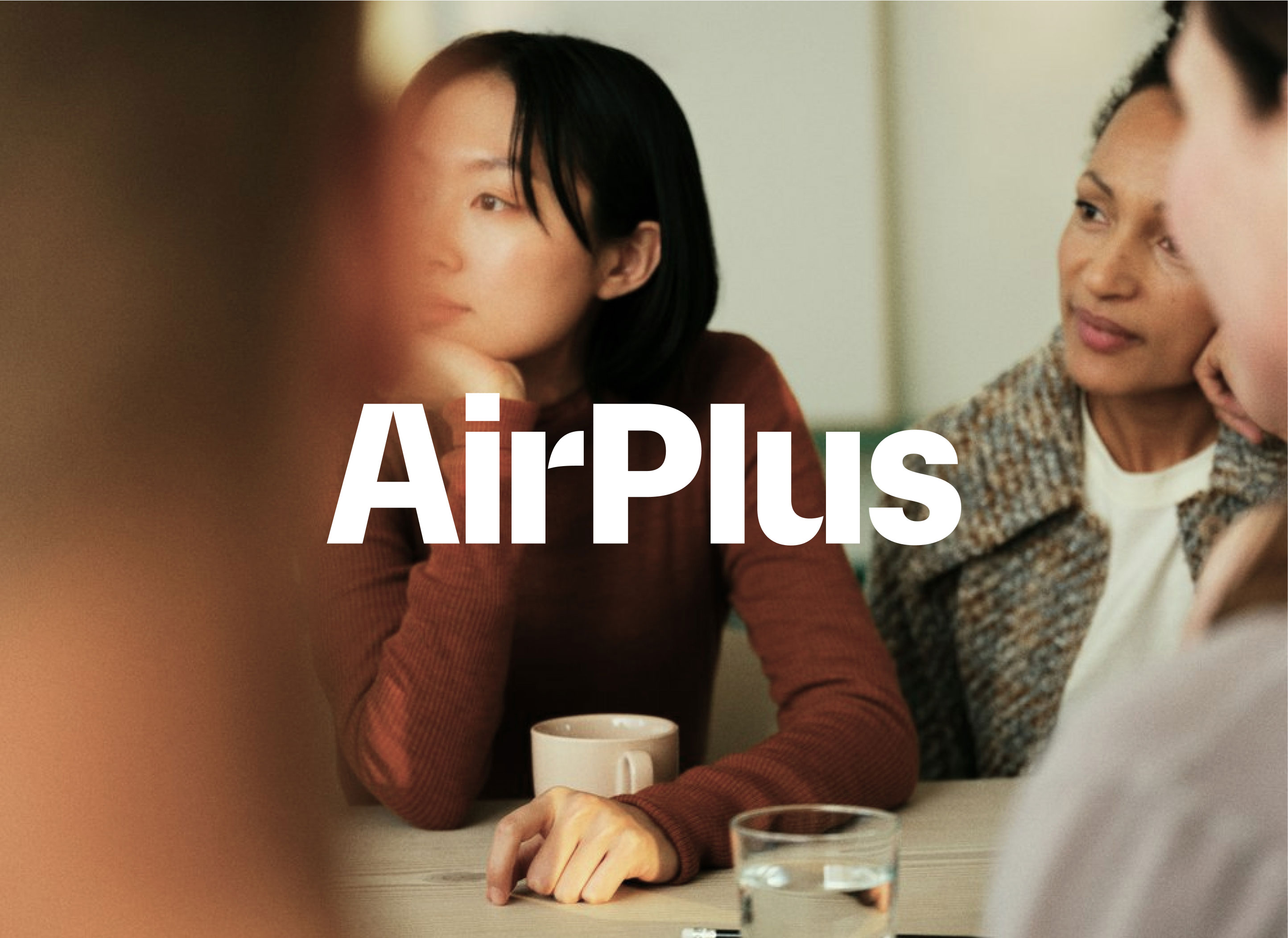 AirPlus wordmark over a photo of people listening around a meeting table with coffee cups