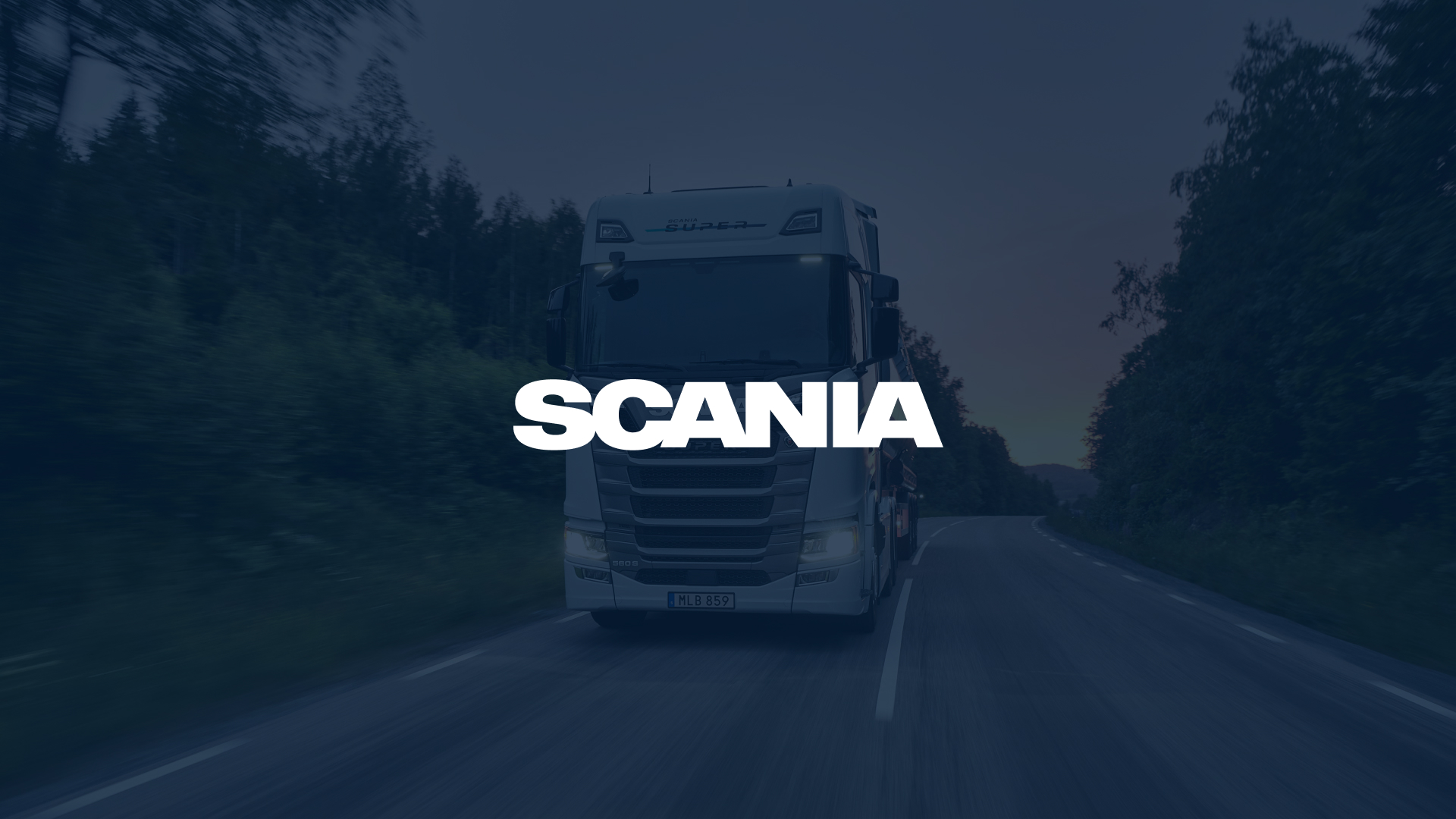 Scania logo over a white Scania truck driving on a forest road at dusk