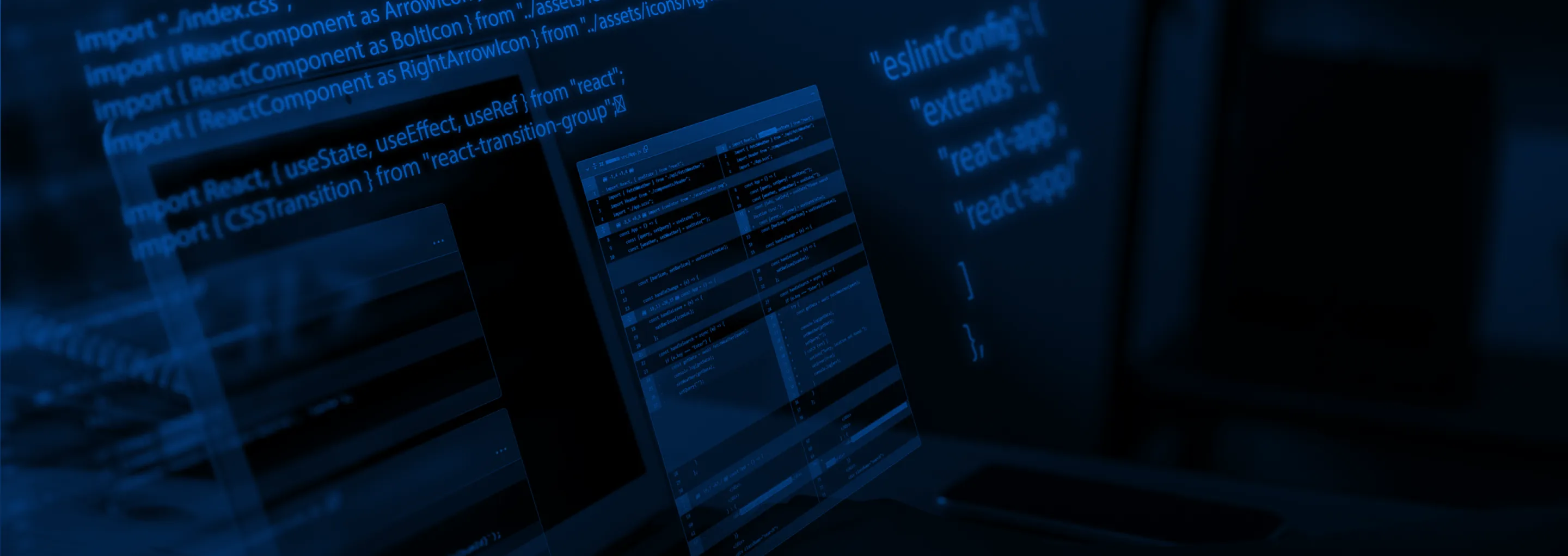 Close-up of computer screens showing lines of code in a dark blue, technical setting