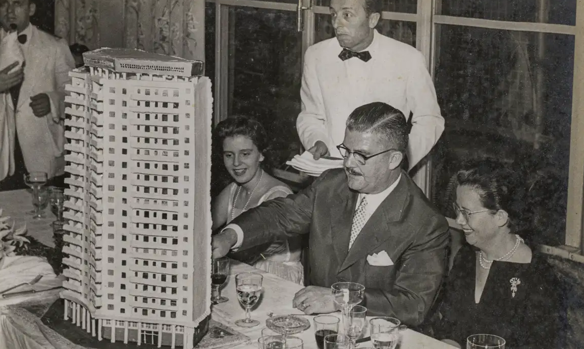 foto preta e branca de Artacho Jurado mexendo em uma maquete de um de seus prédios. 