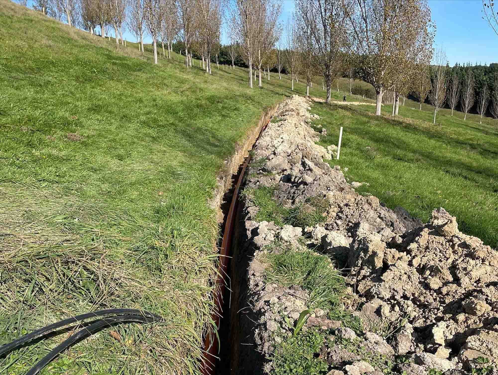 a cable being laid in a grassy field