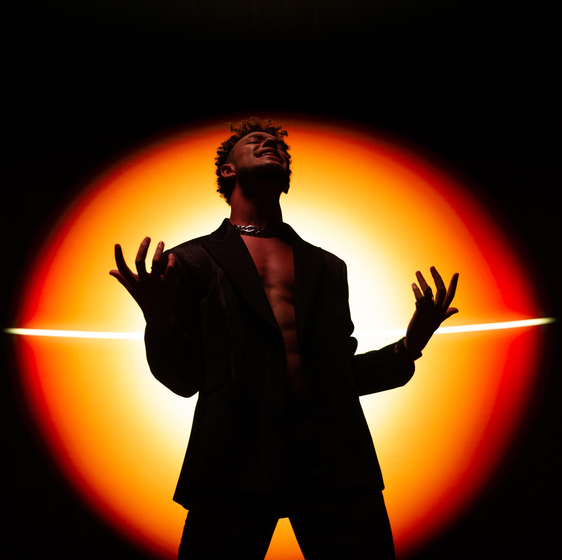 Vincent Darby singing in front of the sun