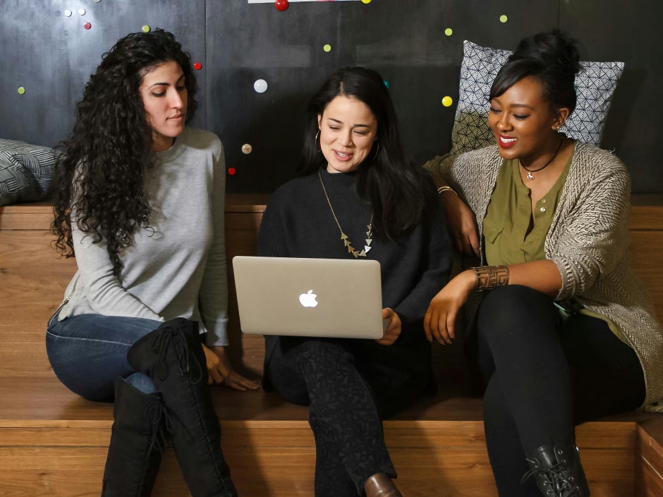 3 girls looking at a laptop together