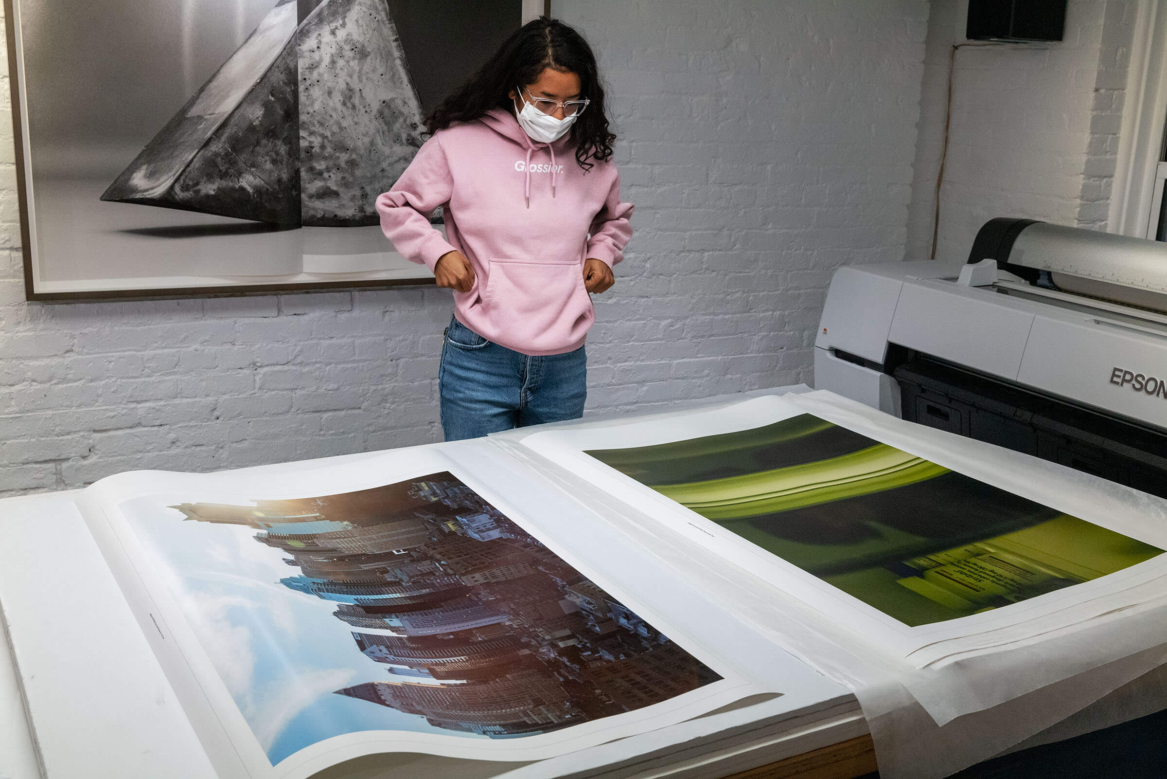 Kia LaBeija examining her prints on table tops in the Brooklyn Editions studio