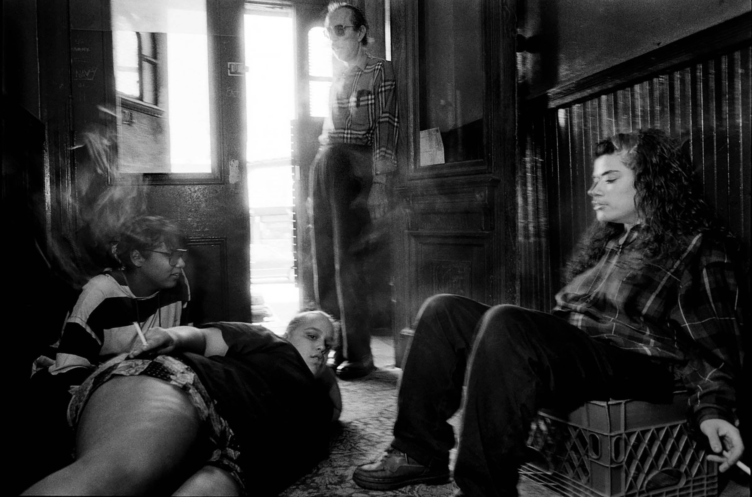 Untitled photograph, showing Uncle Charlie and 3 figured in a doorway lounging and smoking cigarettes