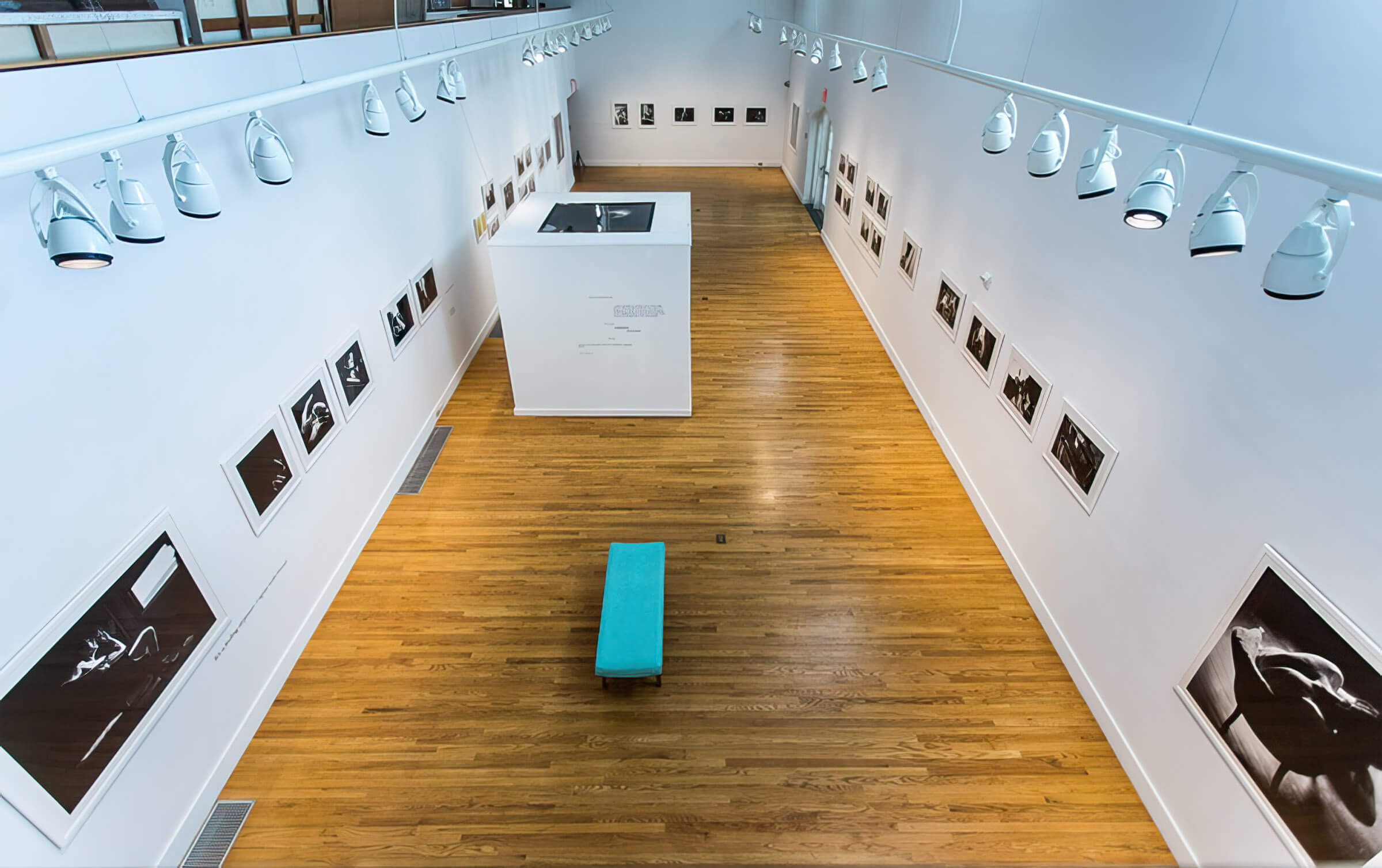 Overhead view of 'Uncle Charlie' exhibition, showing rows of black and white photography hung on the walls