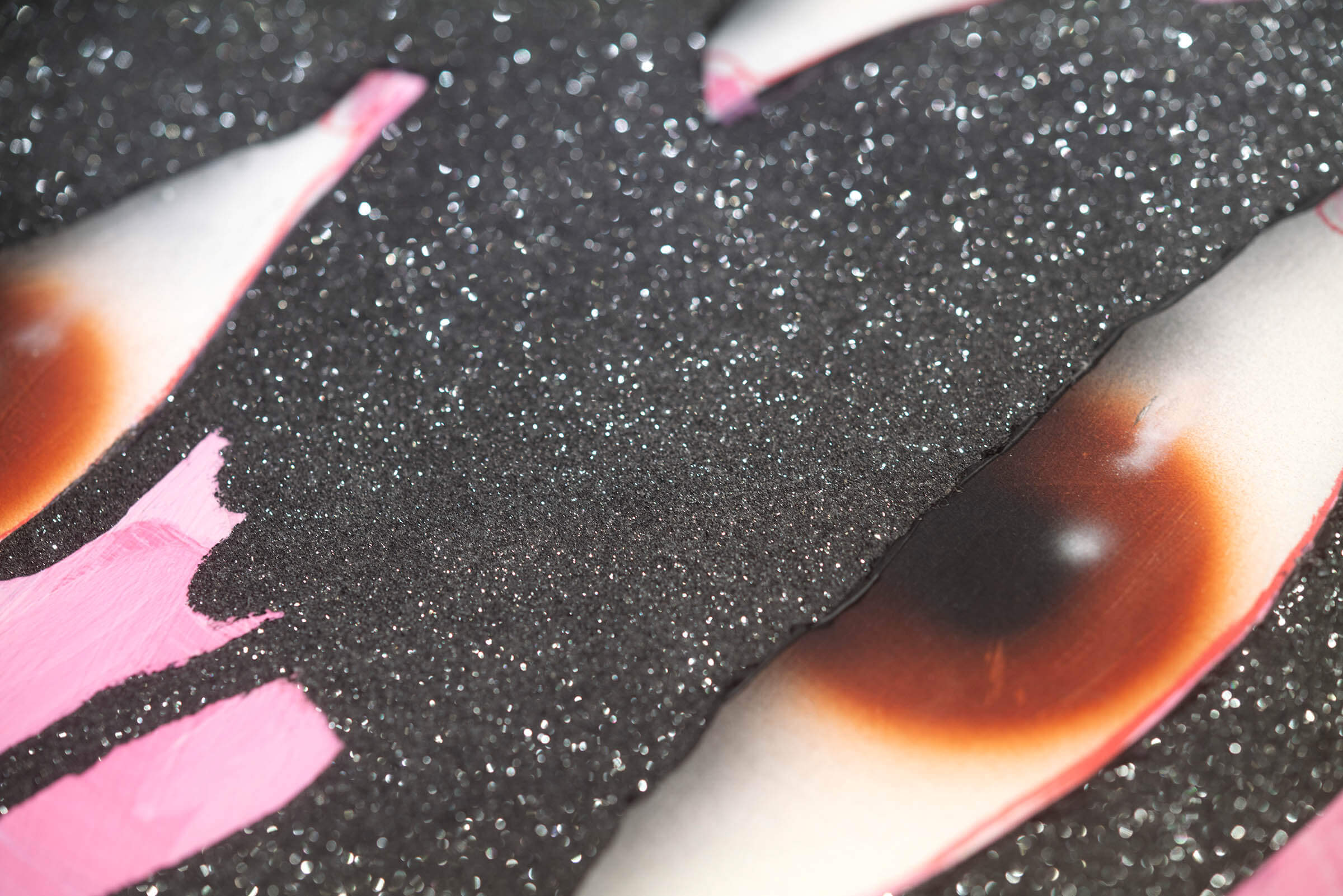 Close-up detail of 'No Patience', showing an eye surrounded by dark grey shimmery matter, dusted with diamond dust