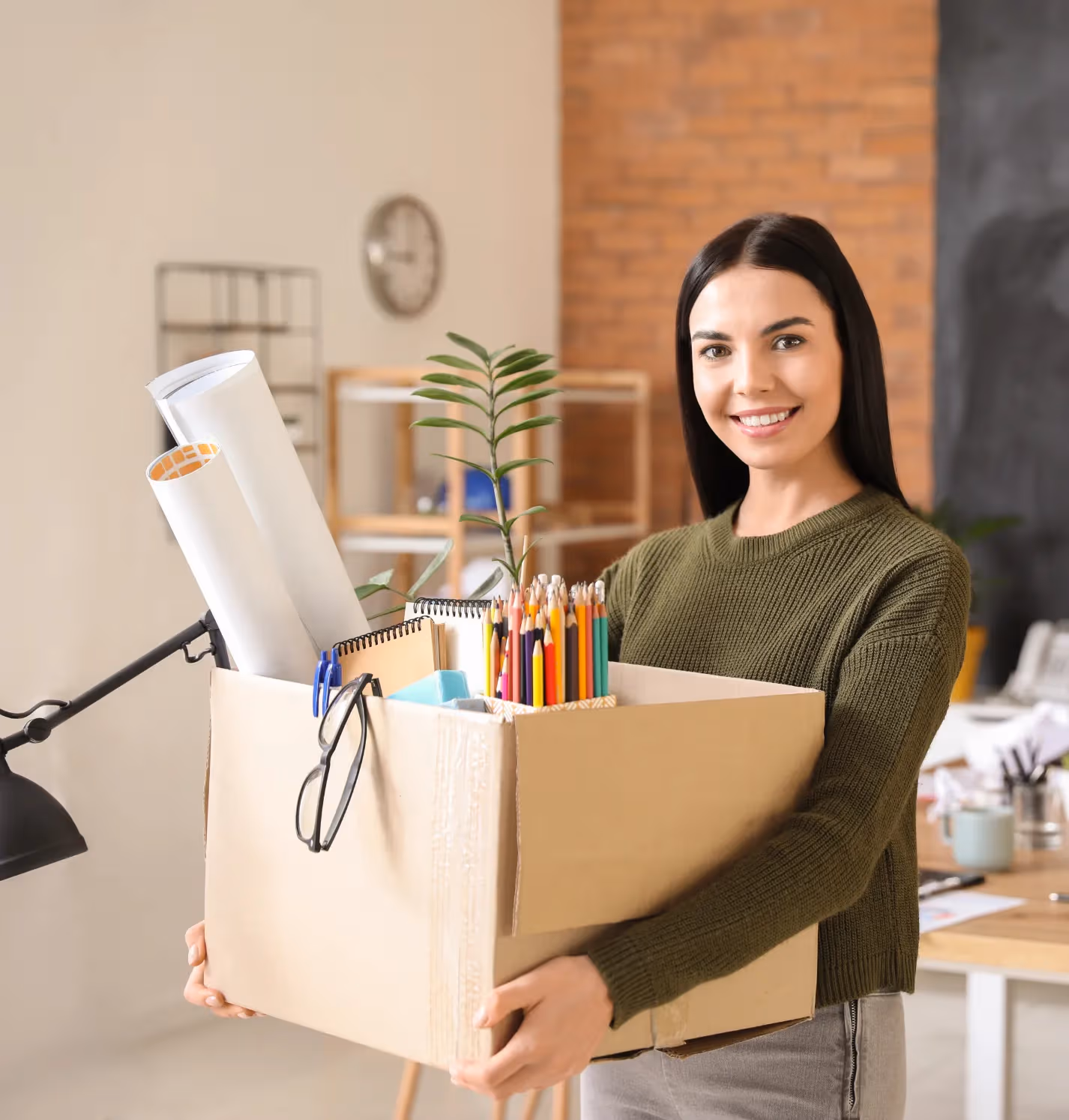 Employé de bureau transportant des fournitures de bureau dans une boîte