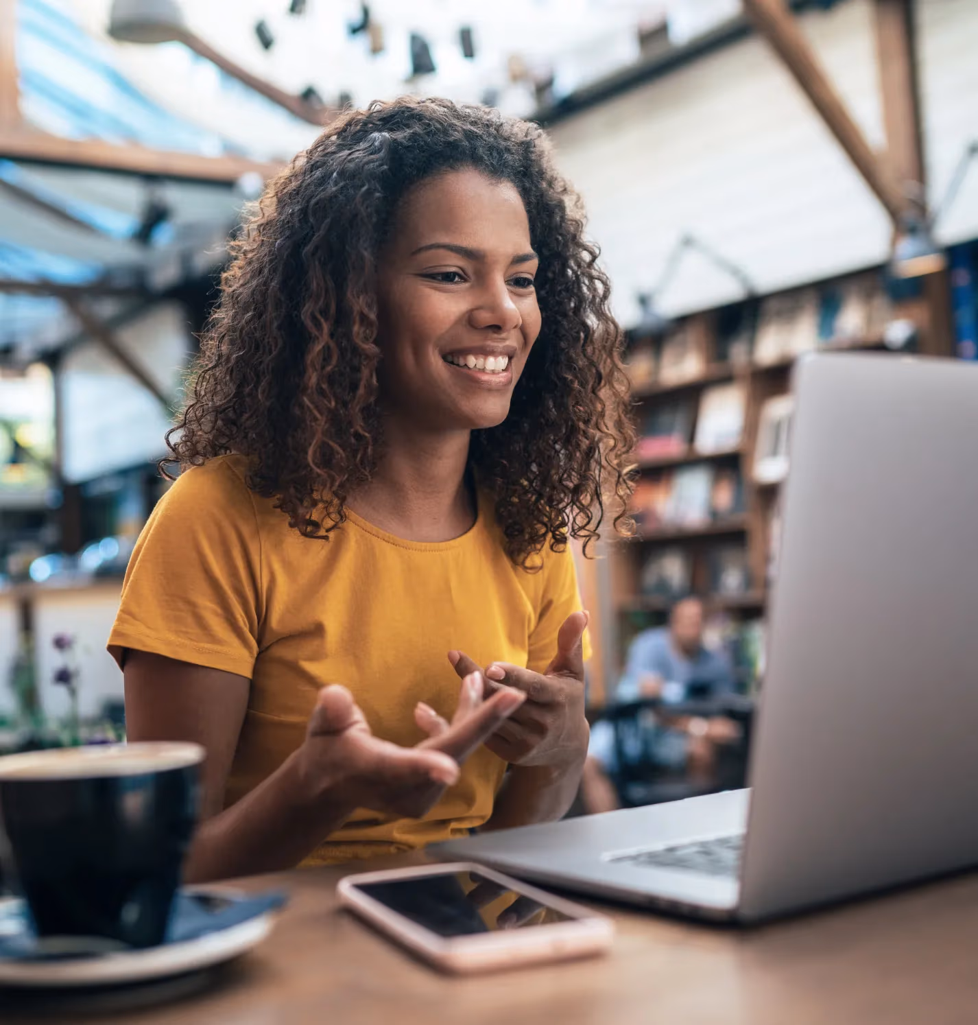 Femme assise à un bureau avec un ordinateur portable pendant un appel vidéo