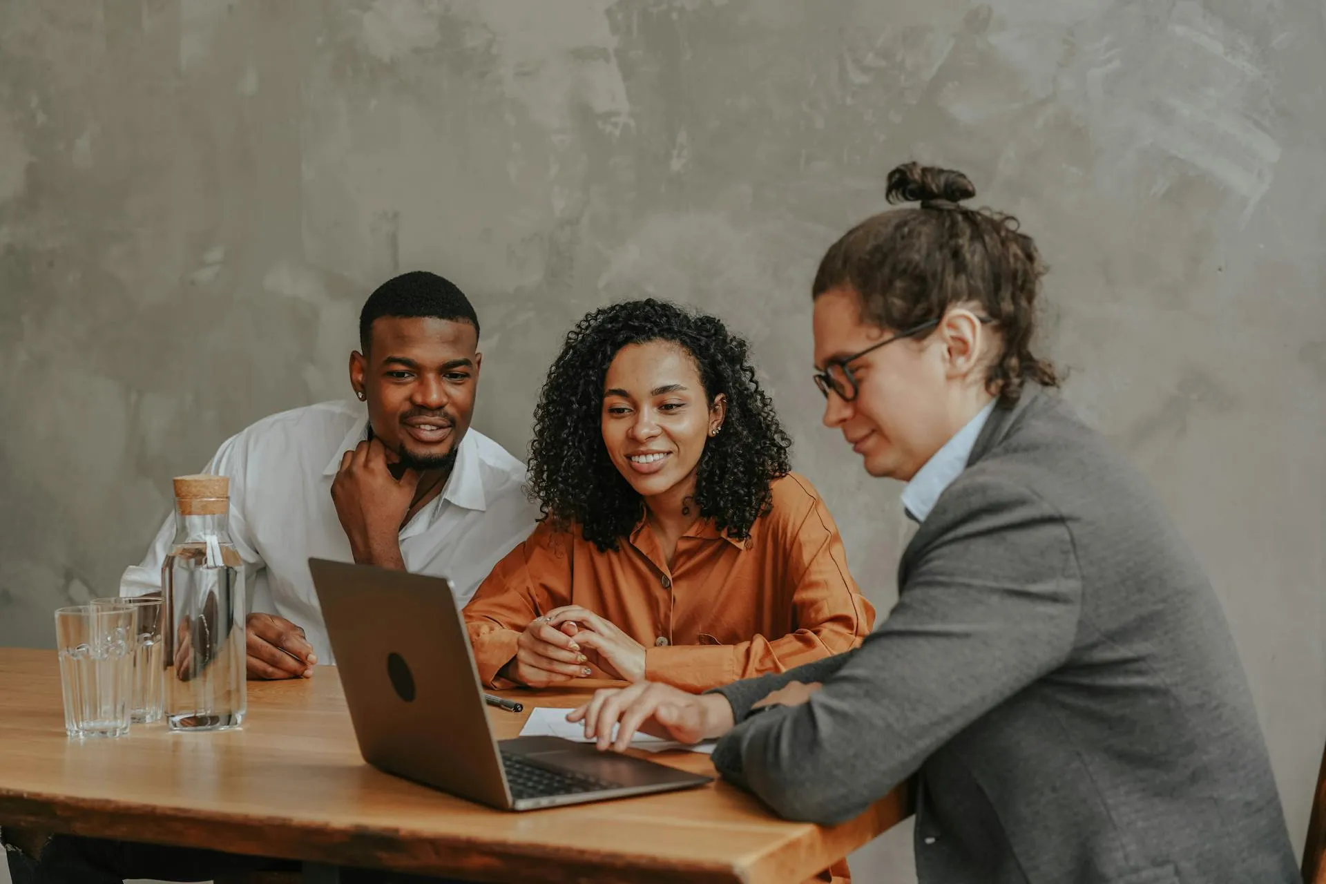 Office workers sitting at a table with the laptop