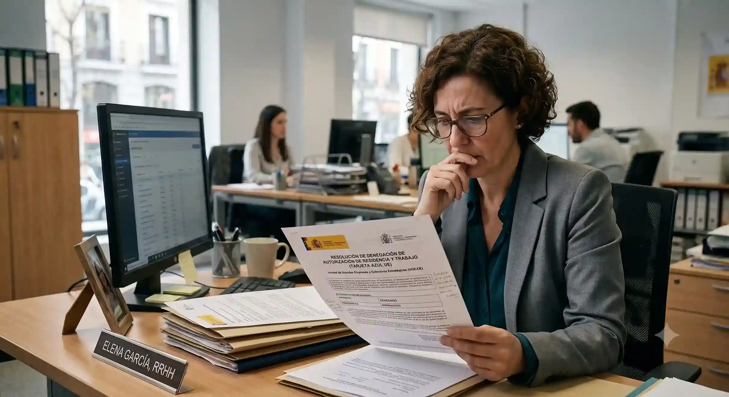 HR manager reviewing a Spain UGE-CE EU Blue Card refusal notice before choosing between an appeal and a refile