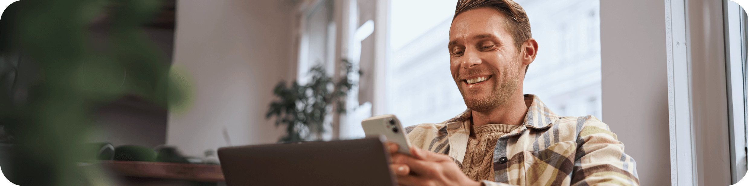 A man is smilling and holding a phone while buying crypto