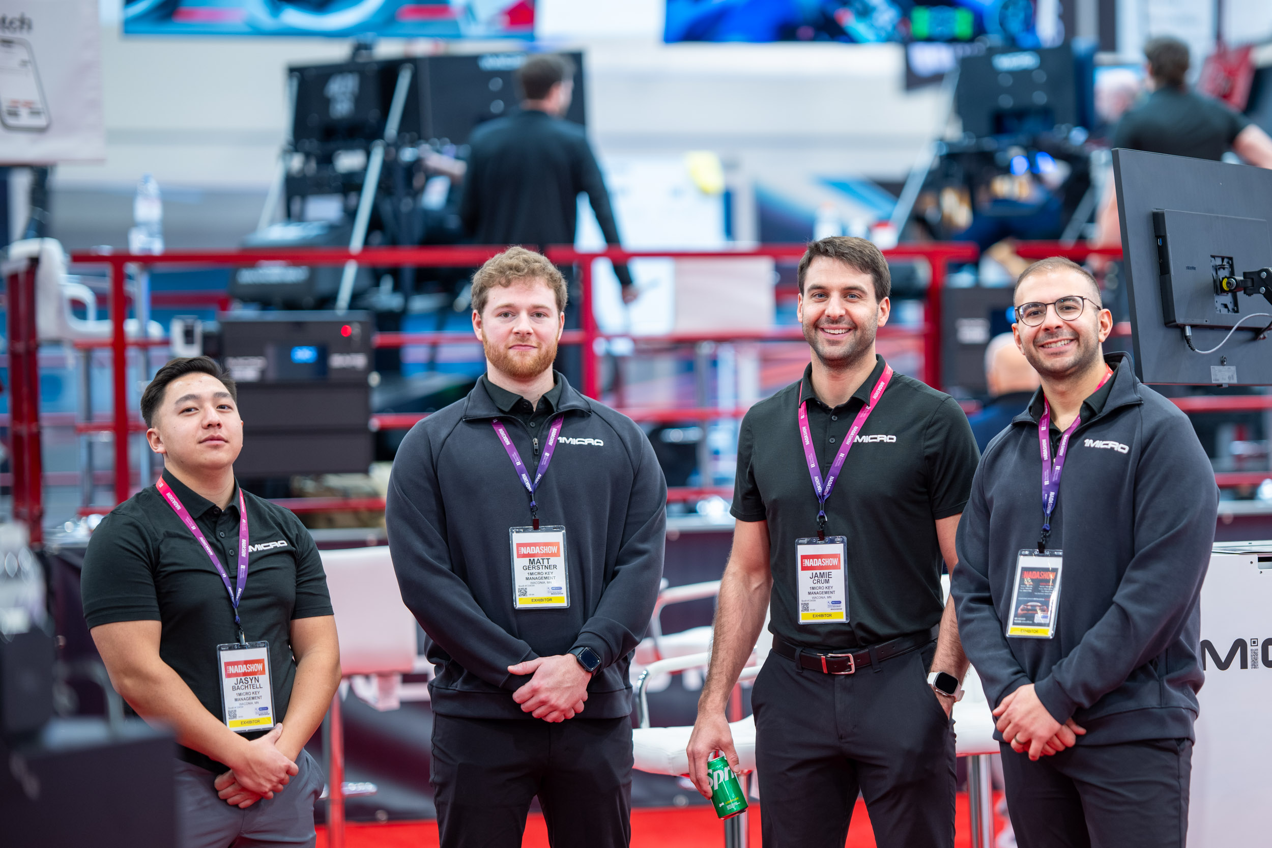 Three of our sales team members, along with the CEO, all smiling at the booth looking at the camera., image