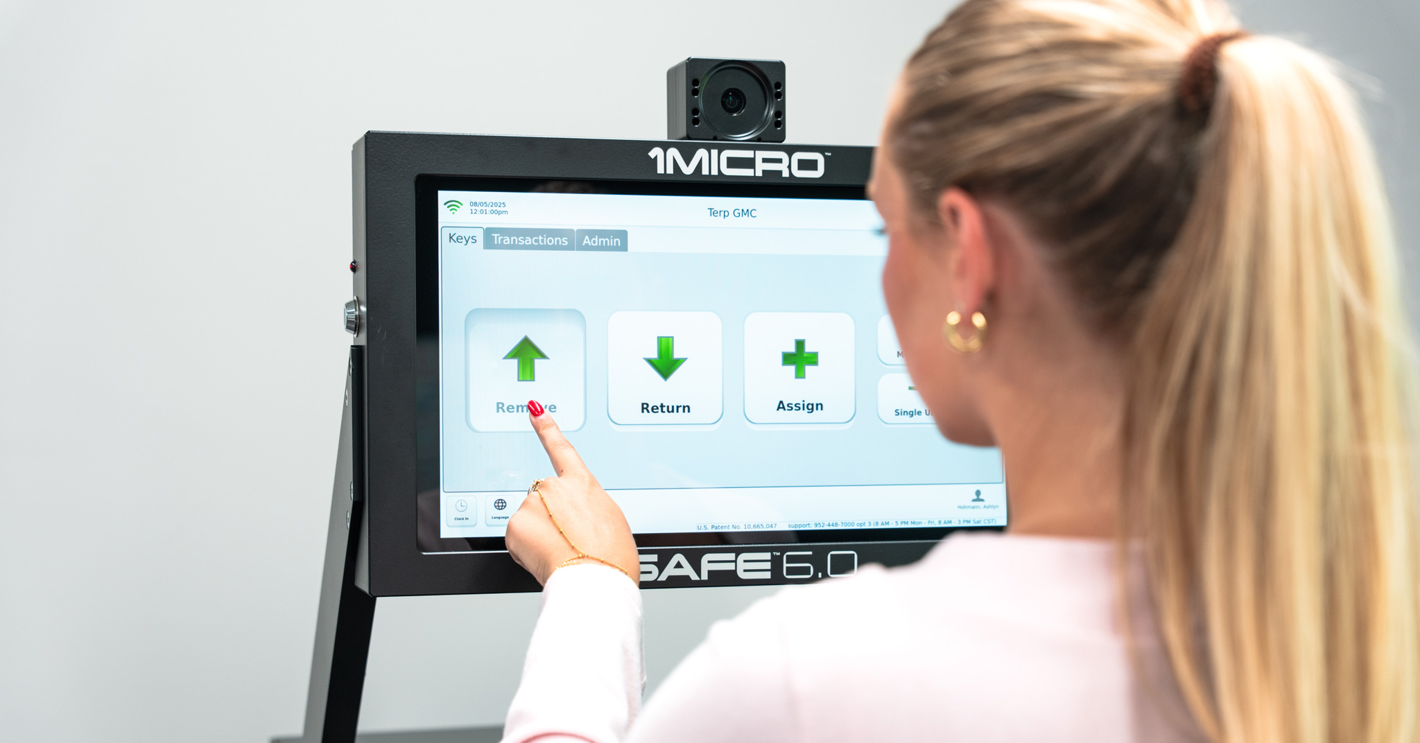 woman standing at iSafe machine and using touch screen to remove a key