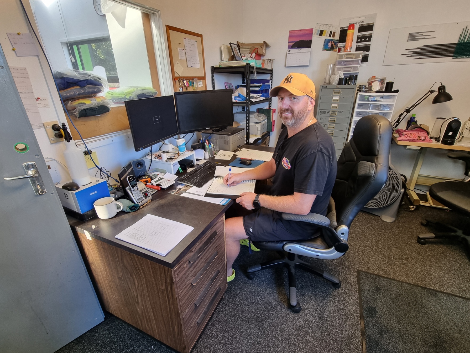 Business owner Paul Vlaming sitting at his desk and smiling