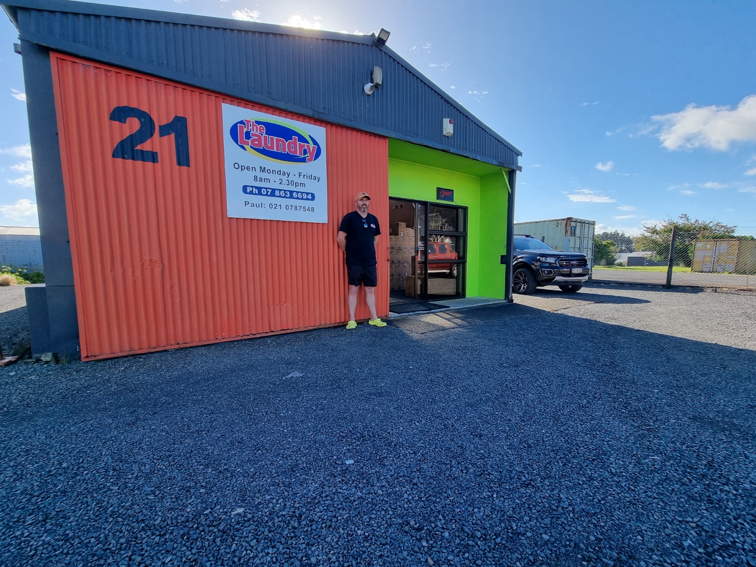 Business owner is standing in front of the main building