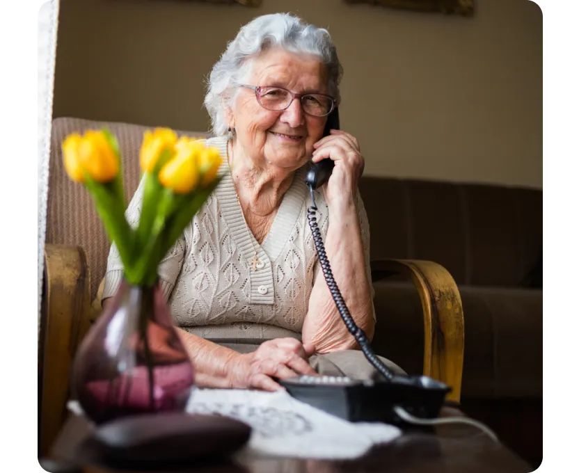 An elderly woman accessing Gro's coaching line via telephone.
