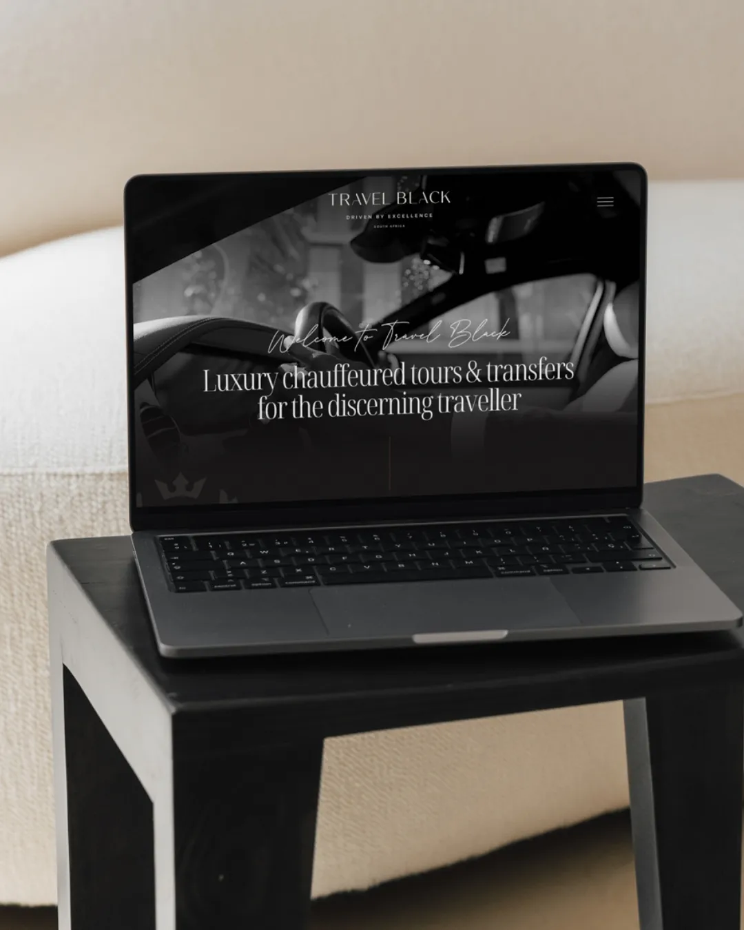 Laptop displaying a webpage for Travel Black offering luxury chauffeured tours and transfers.