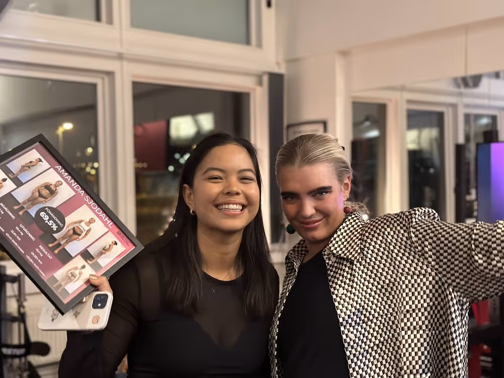 En bild på två tjejer som precis varit med i en tränigstävling varav den ena tjejen håller upp en skyld på sina resultat