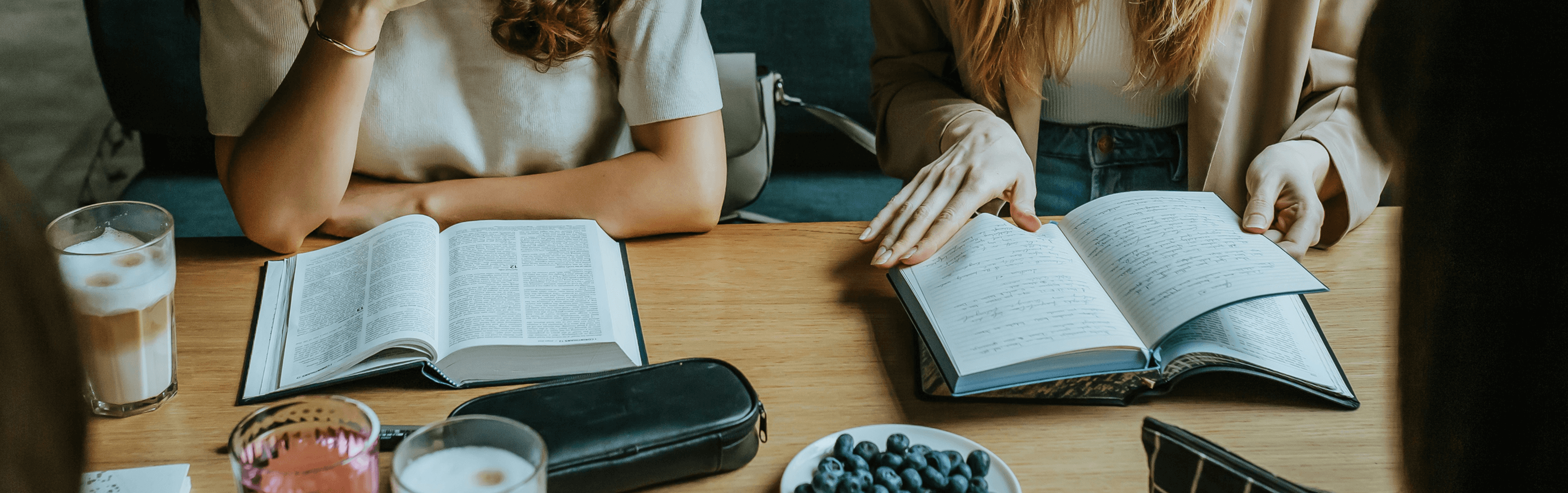 Two people flipping through their bibles