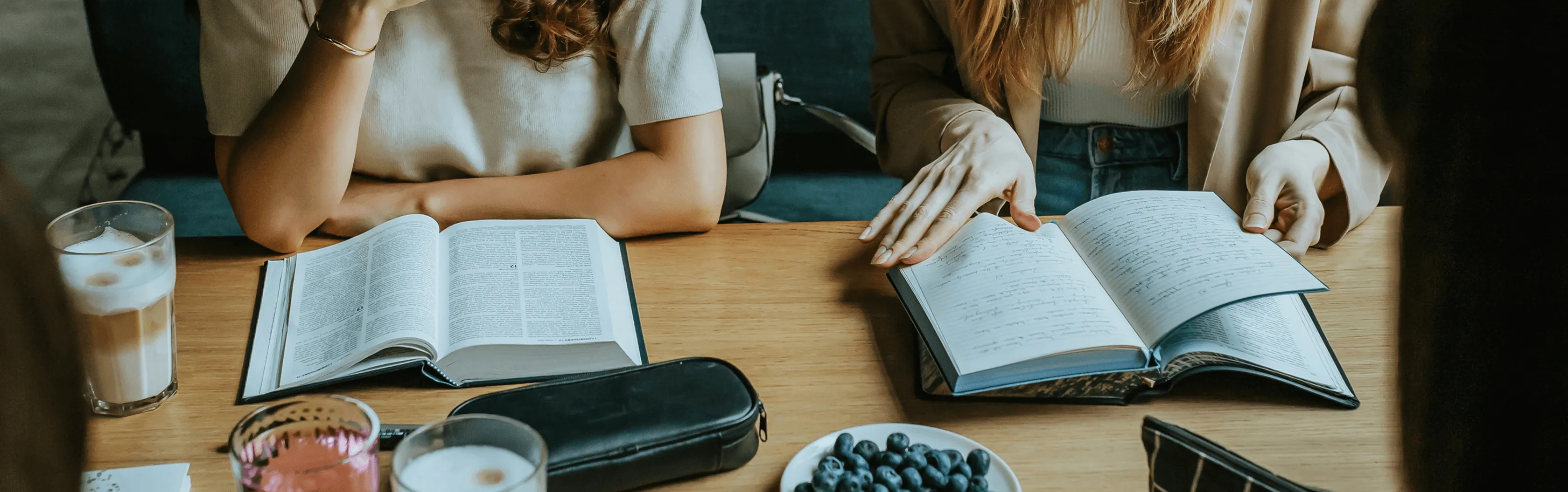 Two people flipping through their bibles