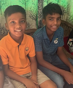 Two children sitting on a bench smiling