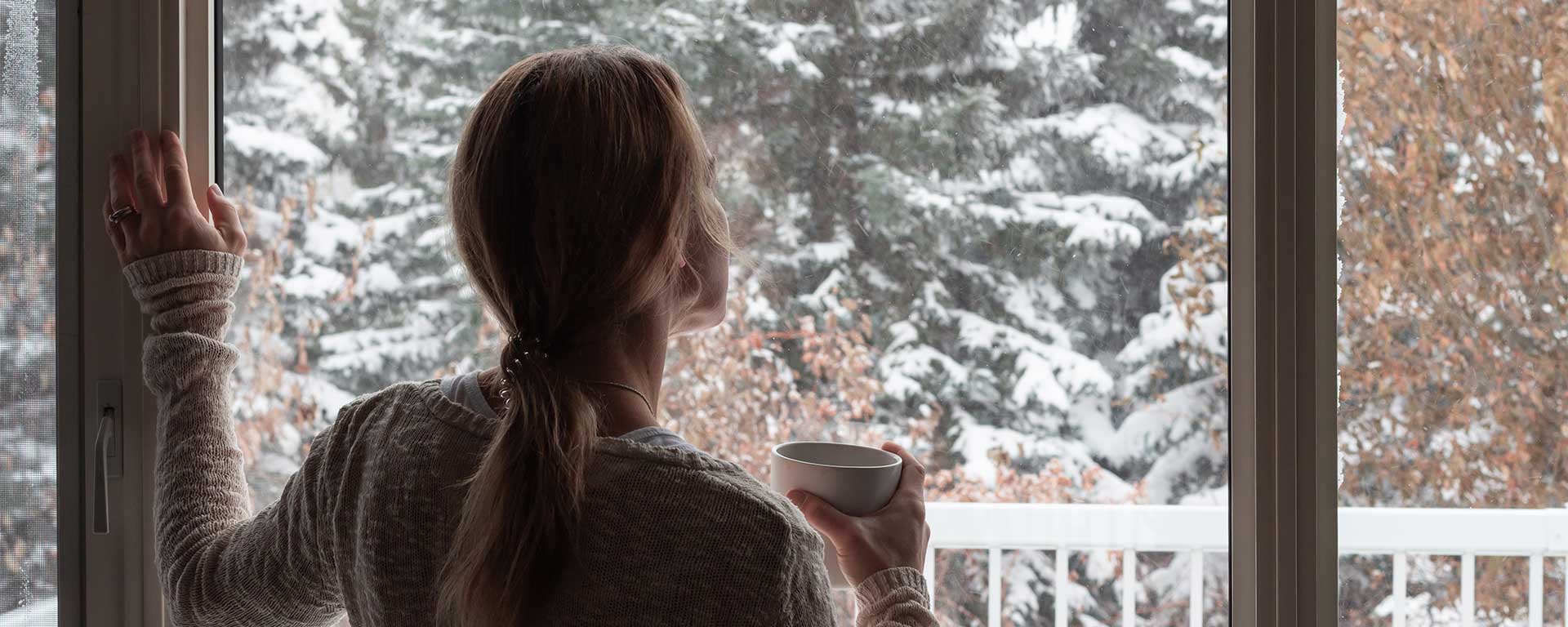 Clean residential window with winter sunlight in a Norfolk Nebraska home, showing how winter window care helps prepare for spring