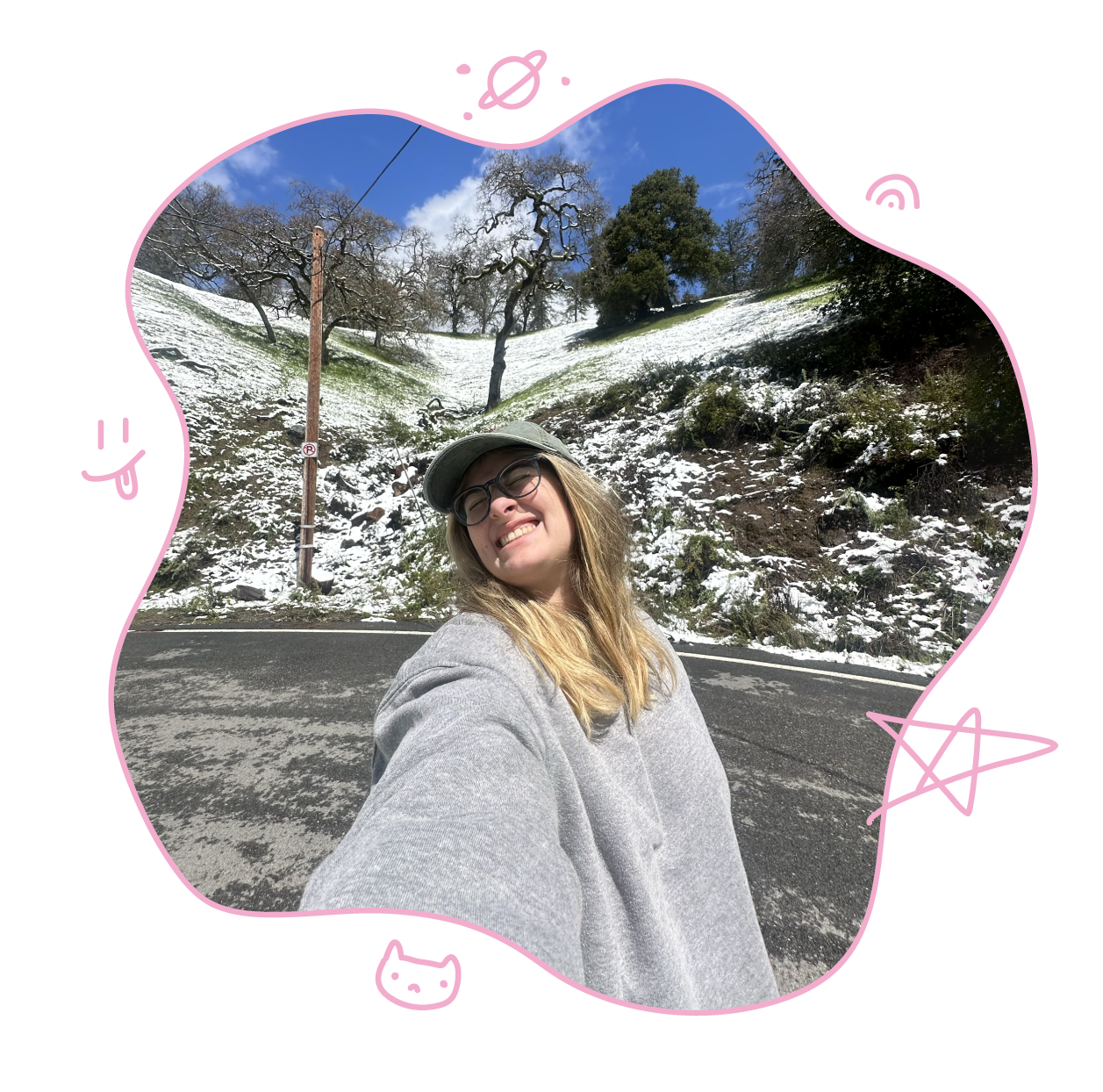 A photo of Lisette wearing glasses and smiling in front of a car on a snowy mountain side