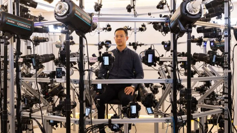A male model sitting in the middle of multiple cameras for body movement detection