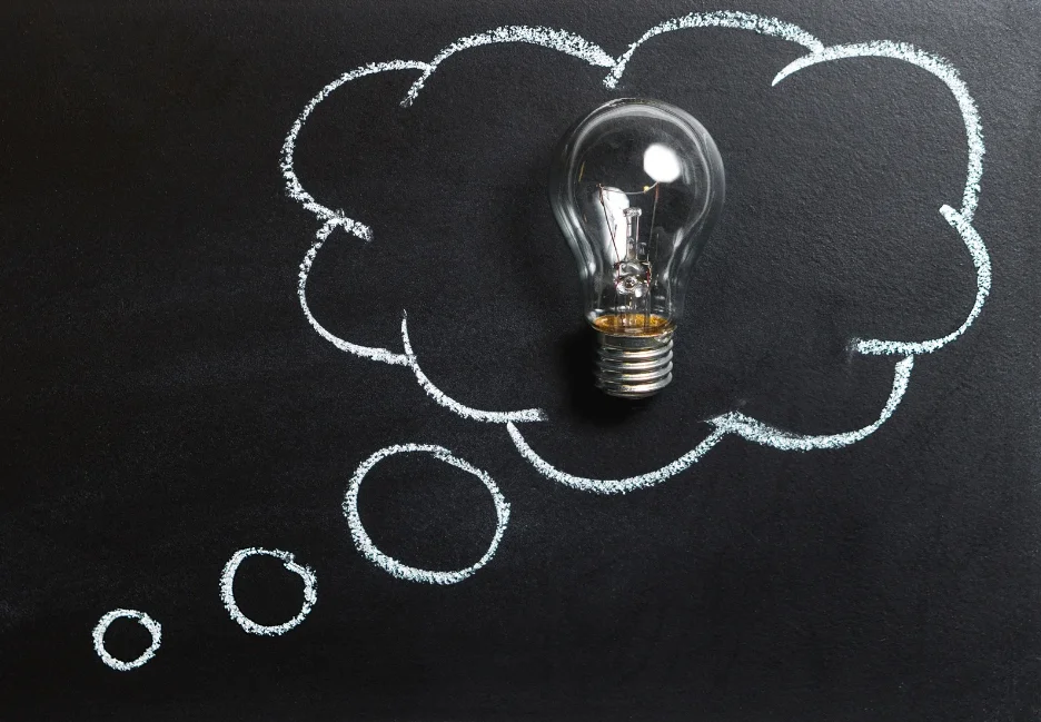 A lightbulb inside a thought bubble on a chalkboard