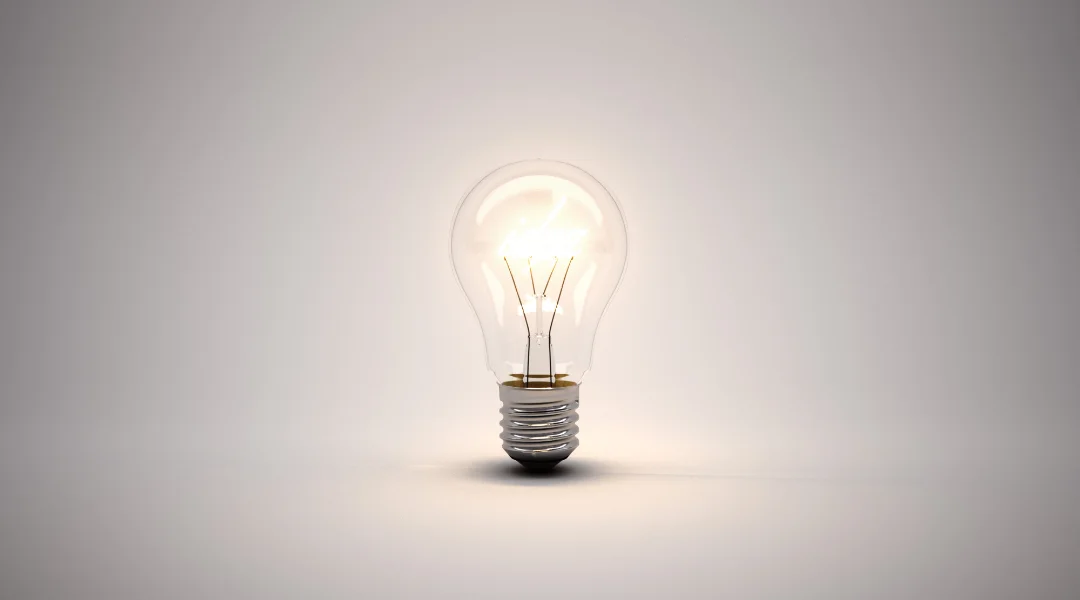 A soft white light bulb lit up with a blank background
