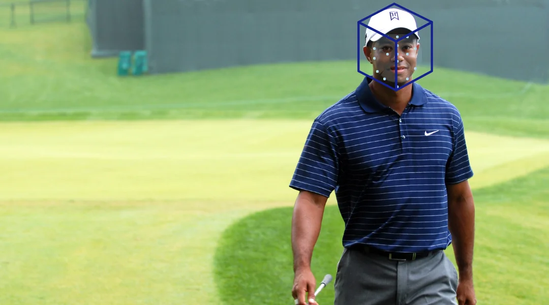 Pro golfer Tiger Woods walking on a golf course while his face is digitally scanned & mapped