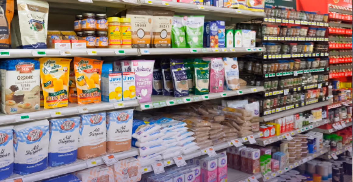 Supermarket aisle shelves stocked with various baking and cooking ingredients in bags and boxes.