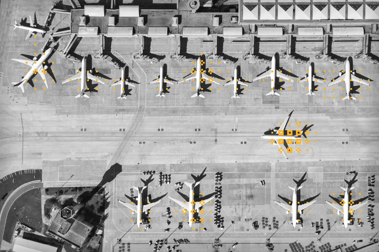 aerial view of an airport with planes lined up around the tarmac