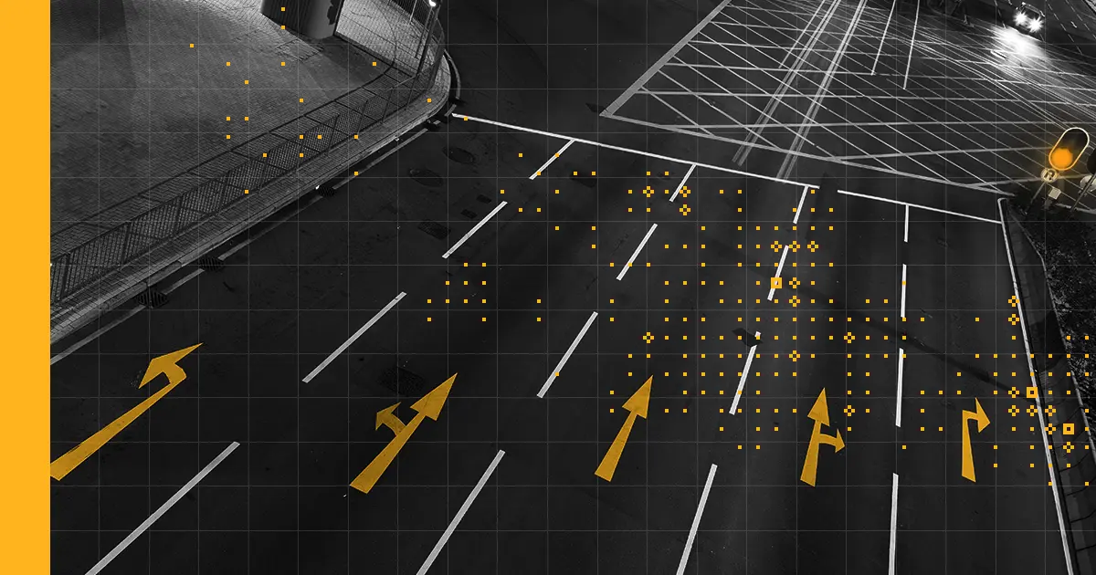 black and white image of an empty highway with yellow arrows pointing straight ahead