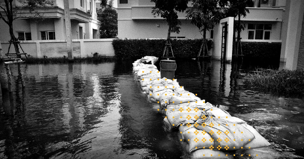 A photo of flooding waters at a person's eye level with an ineffective sandbag wall that has decorative yellow pixel glyphs along the top of it.