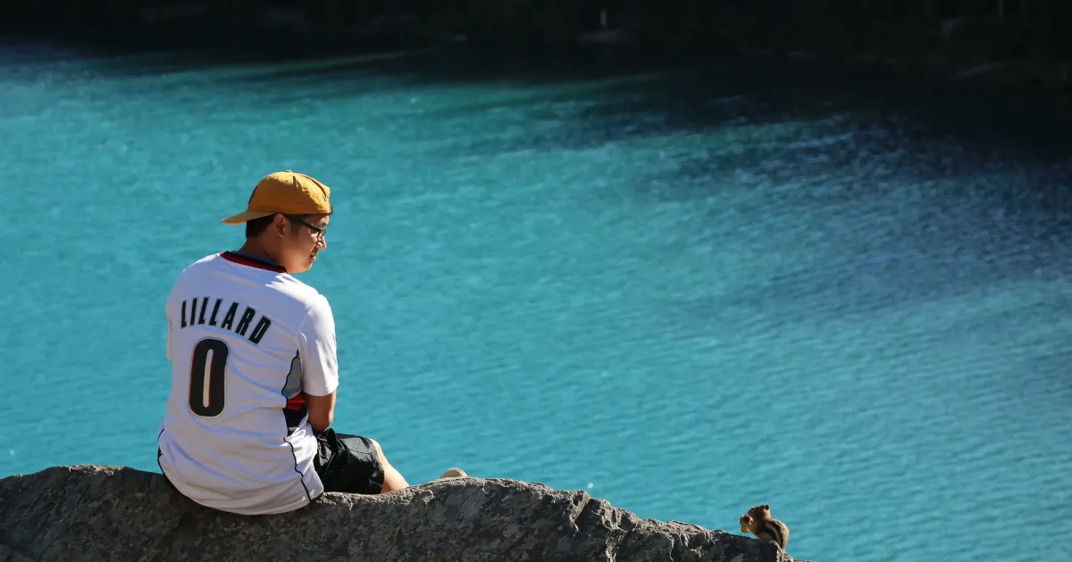 Jimmy sitting on a cliff edge overlooking water below