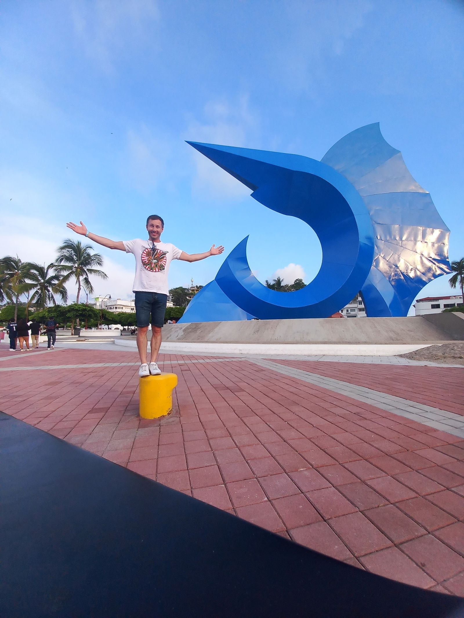 Wes standing in front of the sailfish monument in Manzanillo, Mexico