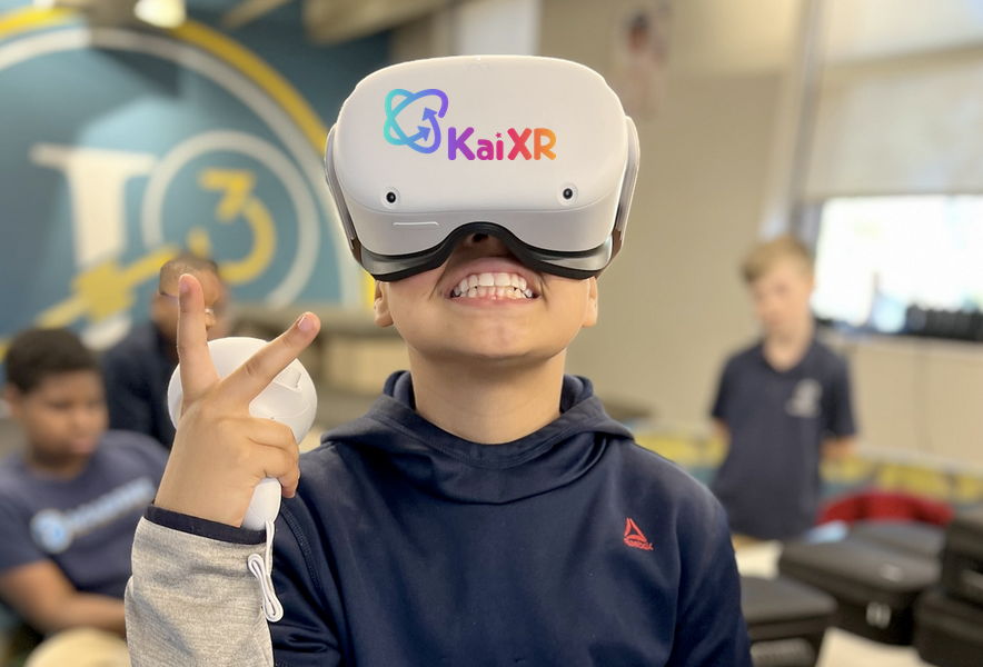 Smiling child wearing a KaiXR virtual reality headset and holding a VR controller, with blurred children in the background.