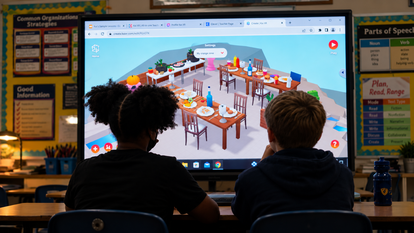 Two students seated at desks in a classroom, facing a large screen displaying a digital interactive scene with tables set with food and objects, with educational posters on organizational strategies and parts of speech in the background.