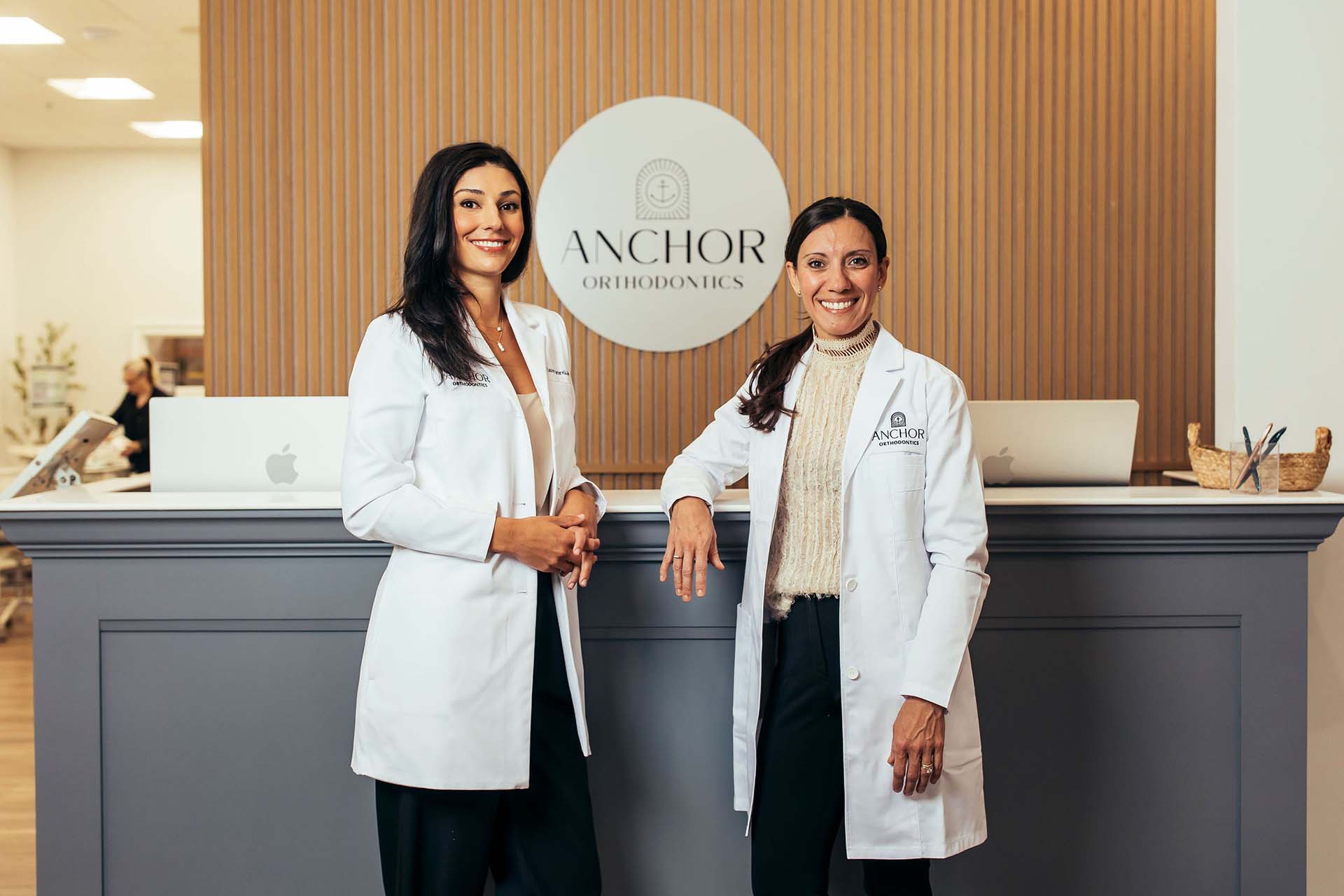 Dr. Lauren Cardarelli and Dr. Courtney Lavigne at the front desk of Anchor Orthodontics in Providence, RI