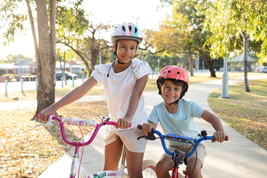 A young man facilitating a consultation, holding up an information sheet in front of some posters with sticky notes on them.