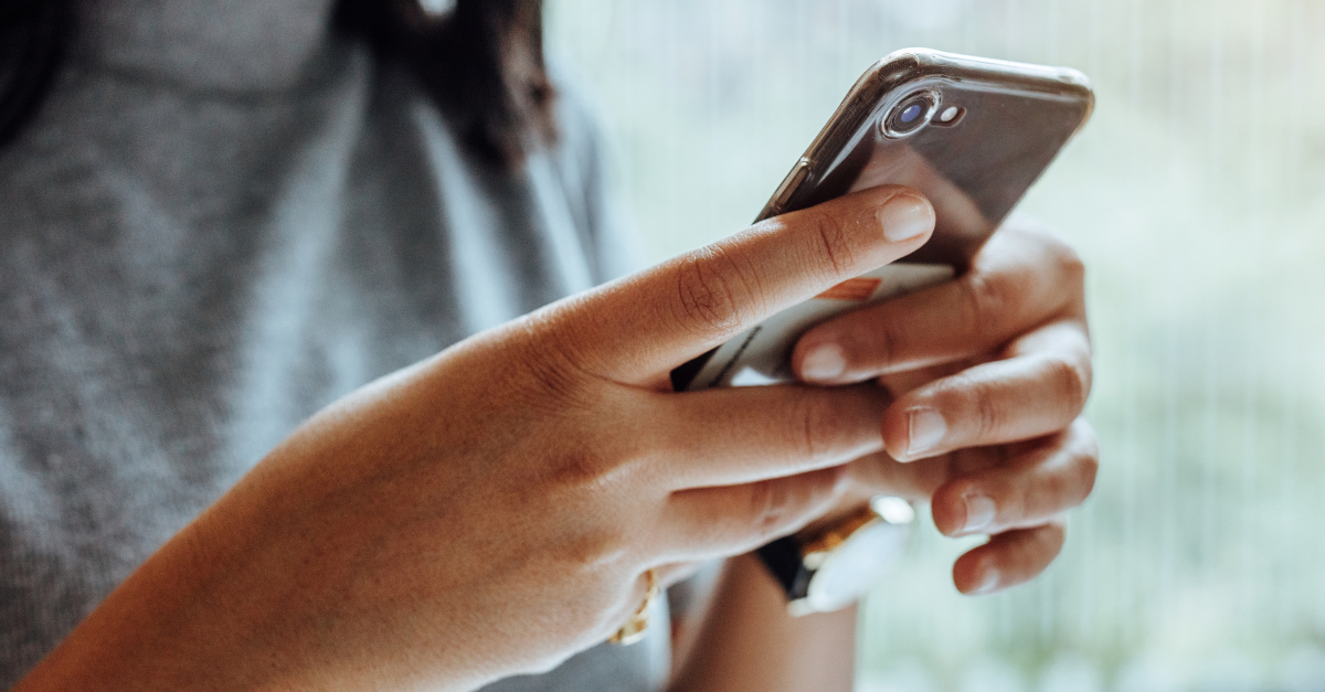 A young person holding a phone.