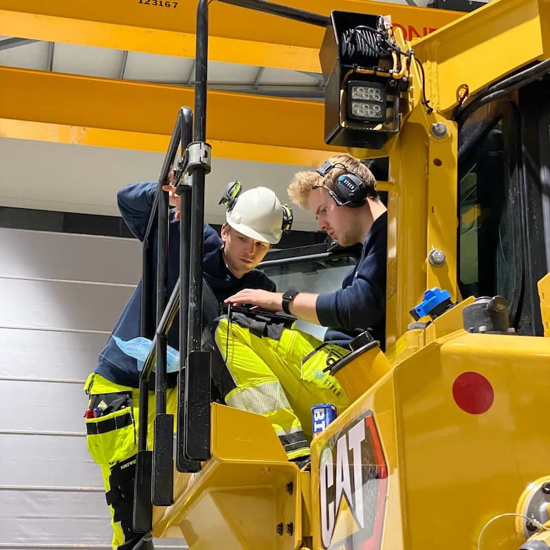 Technicians configuring remote operation system on CAT D8 dozer