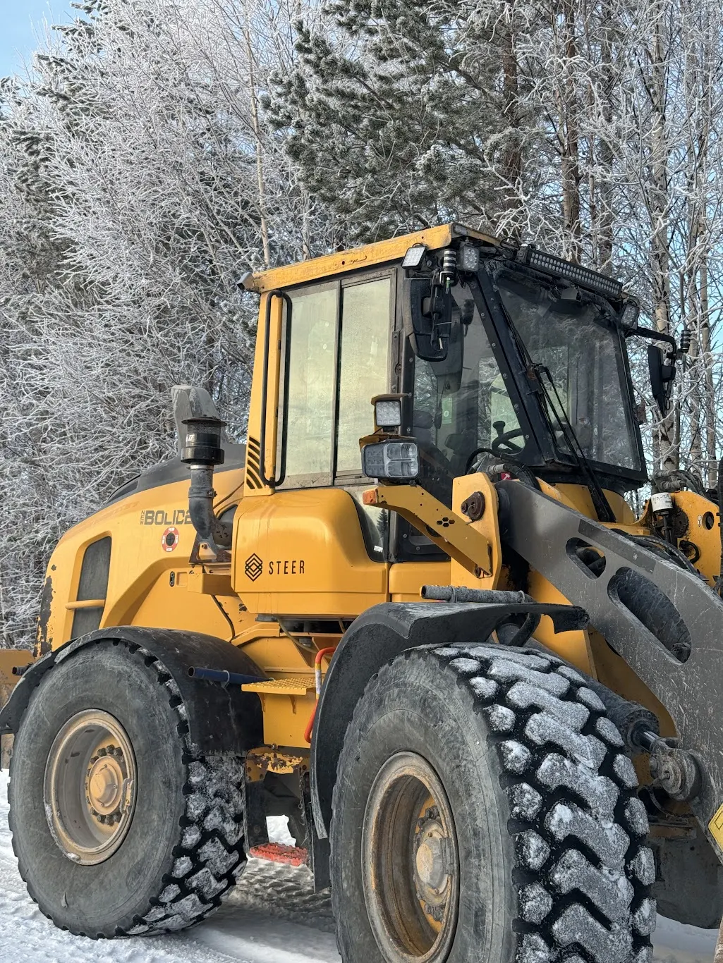 Close-up of a Steer teleoperated Volvo L90 wheel loader in a snowy environment, optimized for road maintenance during post-blast ventilation periods.