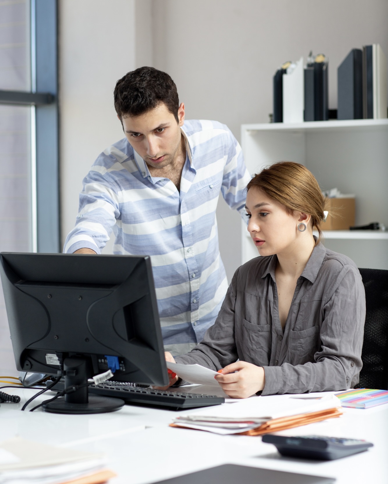 Woman and man looking down thoughtfully in an office setting