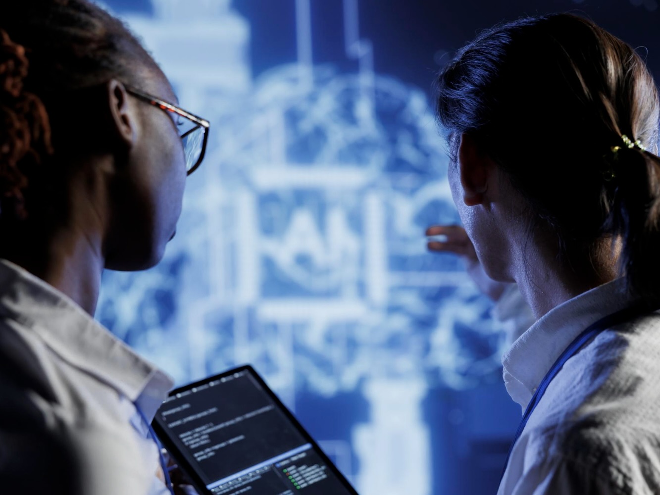 Two colleagues looking at a digital AI visualization display